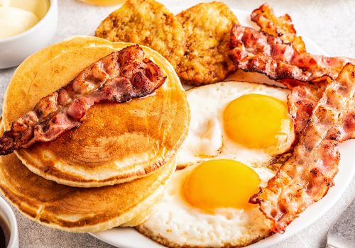 Healthy Full American Breakfast with Eggs Bacon Pancakes and Latkes.